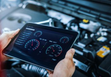 car engine diagnostics. service mechanic using digital tablet to inspect vehicle condition